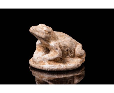 Late Period, Ca. 664 - 332 BC.A steatite frog amulet depicted seated atop a circular flat base. The frog's body is extended f