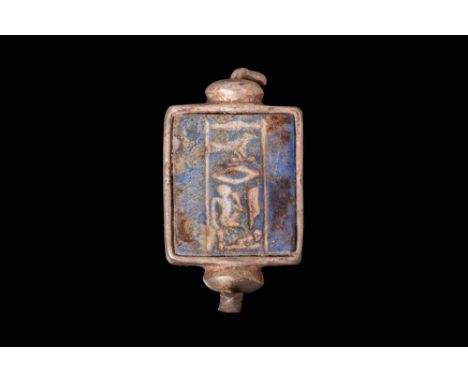 Late Period, Ca. 664 - 332 BC.A lapis lazuli tablet inscribed with a vertical line of hieroglyphs framed in a silver square b