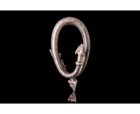 Ca. 300 - 100 BC.A stunning silver earring of annular form. The accessory exhibits a lustrous surface, a curved body, and sma
