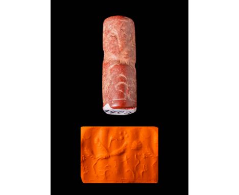 Ca. 1100 - 900 BC.A Mesopotamian red stone cylinder seal. The main item of the design is a large bird, standing with its wing