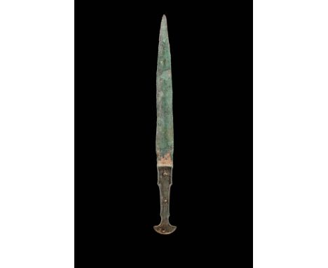 Ca. 1200 - 800 BC.A Western Asiatic bronze sword with a tapering blade and a handle inlaid with red stone. The hilt terminate