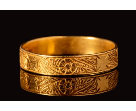 Ca. AD 1500 -1550.A medieval gold posy ring with a round hoop decorated with incised floral motifs alternating with patent cr