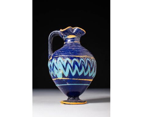 Eastern Mediterranean, Ca. 600 - 400 BC.A core-formed glass oinochoe with an inverted piriform body. It is supported on a sma