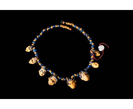 Ca. 500 - 300 BC. An amazing Phoenician necklace with eight glass head-shaped pendants. The necklace is comprised of dozens o