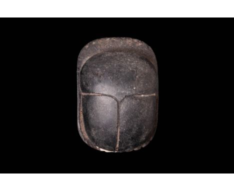 Ca. 664 - 332 BC.A scarab with an ovoid body, carved from black stone, presenting pleasingly smooth surfaces. The topside of 