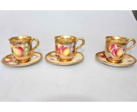 Three Royal Worcester fruit painted cups and saucers, having gilt gadroon borders and interiors, signed.