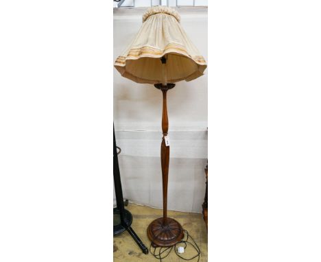 A turned and carved walnut standard lamp on circular base with bun feet, height excluding shade 132cm