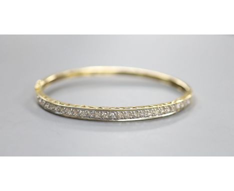 A modern 585 yellow metal and diamond chip set hinged bangle, interior diameter 62mm,gross weight 10.6 grams.