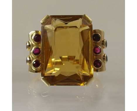 A 1950s ruby and citrine cocktail ring the bright yellow metal set with an emerald cut citrine, corner set with scrolled shou