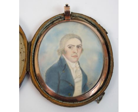 An 18th Century portrait miniature of a gentleman in blue coat, oil on ivorine, the reverse with enclosed locks of hair, in y