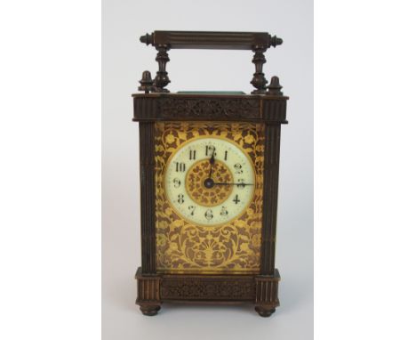 A 19th Century French brass carriage clock with fluted sides and floral friezes, the side and face with highly decorative pie