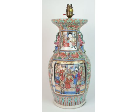 A Canton famille rose baluster vase (converted to a lamp), painted with panels of a court scene and warriors in conflict, wit