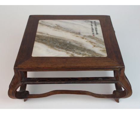 A Chinese hardwood low pedestal the marble top with two rows of calligraphy and on scroll legs joined by stretchers, 20 x 19c