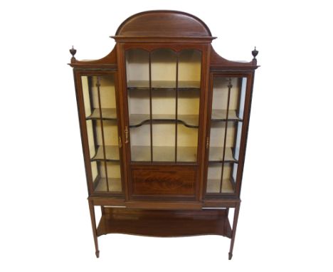 An Edwardian mahogany display cabinet the central astragal door flanked by a pair of doors enclosing shelves above a shelf, 1