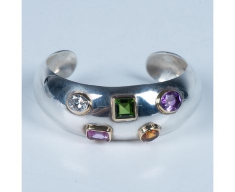 Polished sterling silver domed cuff with five multi color faceted stones. It sits beautifully on the wrist. Backstamp Mexico 