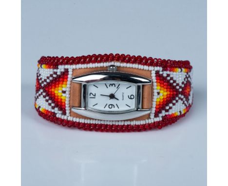 Intricate hand beaded abstract design set on leather. The silver tone quartz watch has a nice shape and sits atop the natural