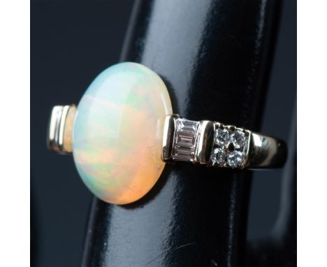 Beautiful ring with 6 baguette-cut, and 8 round brilliant-cut diamonds. It has a large center opal stone that weighs 5.62cts.