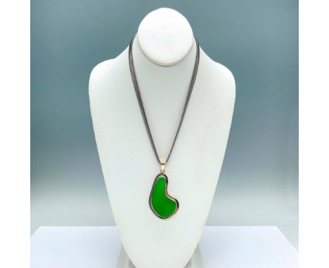 Beautiful green sea glass pendant set in sterling silver hanging from a Milor stainless steel chain. The pendant measures 3"L