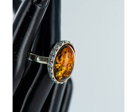 Oval cabochon honey amber stone set in decorative sterling silver surround. Size 7.25. Issued: 20th centuryCondition: Age rel