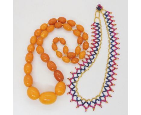 A string of amber coloured beads, largest bead approx 24mm x 18.3mm, weight 43.6gms, together with a seed bead collar necklac