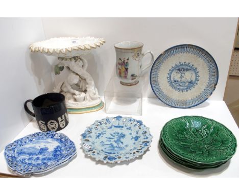 A collection of antique pottery including five green glazed strawberry plates, a Wedgwood black basalt sporting mug, designed