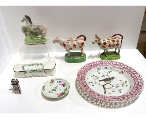 Two antique pottery cow creamers, a zebra flatback, a French enamel scent phial case, a ribbon border plate painted with a bi