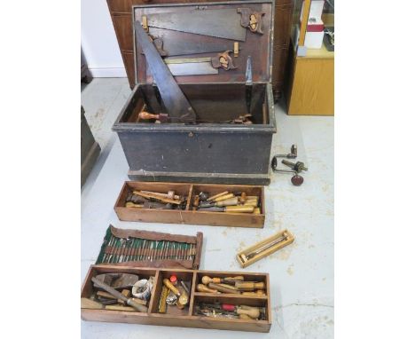A 19th century pine carpenters toolbox with a good selection of tools including wood drill bits, chisels, saws, planes 