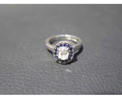 A good diamond and sapphire engagement ring - the central cut diamond 0.6ct, colour G, VS1 surrounded by 14 sapphires set in 