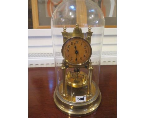 A brass Anniversary clock under a glass dome 