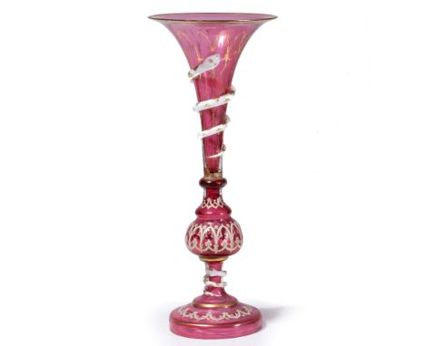 A VENETIAN RUBY GLASS TRUMPET VASE with applied enamel Gothic tracery decoration and with knopped stem, circular spreading ba