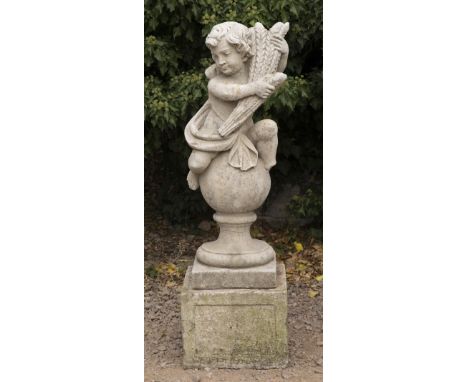 A CAST CONCRETE SCULPTURE depicting a boy in classical dress holding a sheaf of corn and perched on a ball finial 102cm high 