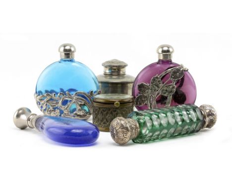 A COLLECTION OF SIX WHITE METAL MOUNTED GLASS SCENT BOTTLES to include moon flask style examples, amethyst tear drop shaped e