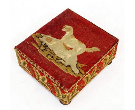 A VICTORIAN NEEDLEPOINT TAPESTRY FOOTSTOOL depicting two dogs on a red ground with ferns around the border, standing on four 