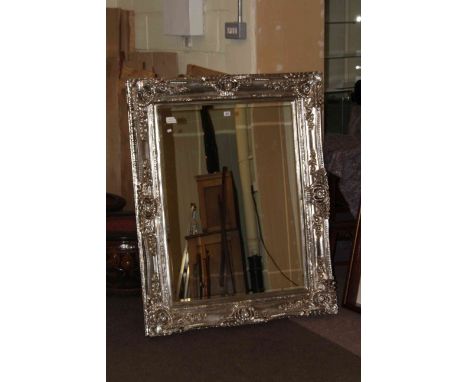 Ornate silvered framed bevelled wall mirror, 130cm by 103cm overall