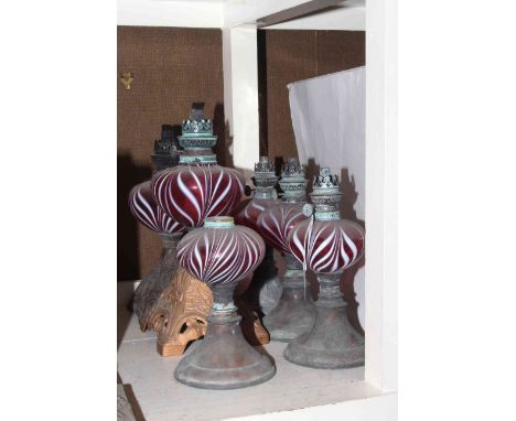 Six oil lamp bases each with ruby and white streaked reservoirs