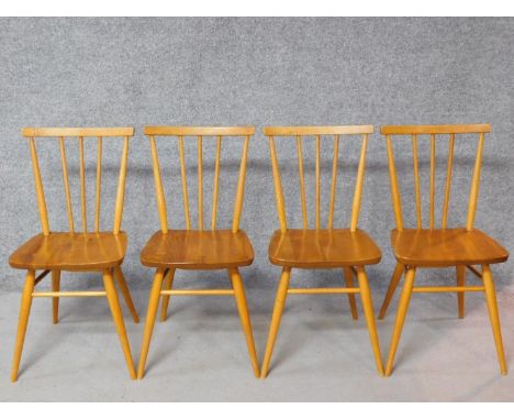 A set of four vintage Ercol style elm seated dining chairs with beech stick backs, rails and legs. British Standards kitemark