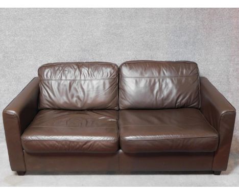 A dark tan leather upholstered two seater sofa bed. H.70 W.180 D.100cm (sofa) 