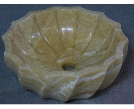 A carved and polished alabaster wash basin with a scalloped spiral design. H.5 W.42 D.42cm 