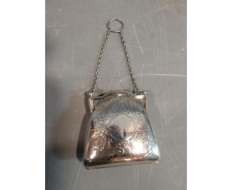 An Edwardian sterling silver ladies coin purse suspended from chain. It has scrolling engraved floral and foliate detailing a