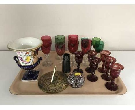 A tray of ruby tinted glasses, coloured glass, brass sundial, glass paperweight etc 