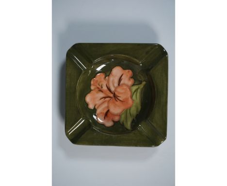 A Moorcroft pottery ashtray featuring the vibrant Hibiscus pattern. This square-shaped piece has gently upturned corners and 