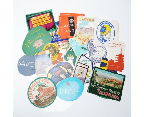 A vibrant collection of approximately 100 vintage hotel luggage stickers and stemware coasters from around the globe, primari