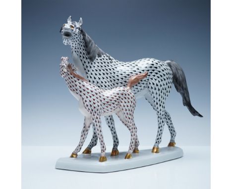A beautifully handcrafted Herend porcelain figurine depicting a mare and her foal in a resting pose, adorned with the iconic 