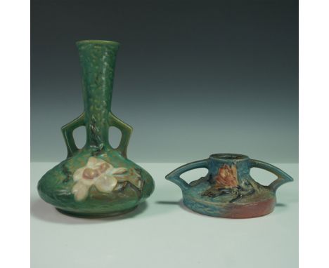 A charming duo of Roseville Pottery items from the Magnolia pattern, including a green bud vase and a blue candle holder. The