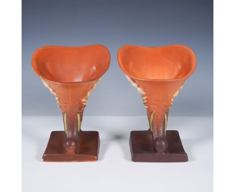 A striking pair of Roseville Pottery cornucopia vases in the Freesia pattern, finished in a warm tangerine brown glaze. These