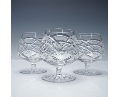 Set of three cut crystal brandy snifters featuring a distinctive crisscross and fan motif with star-cut bases. These glasses 