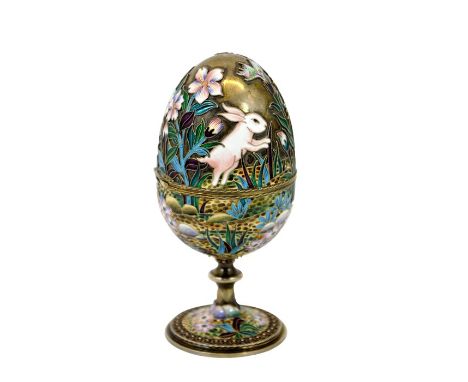 A Chinese silver gilt and champleve enamel egg, modelled with rabbits ad flowers, on pedestal stem, opening on a hinge, pseud