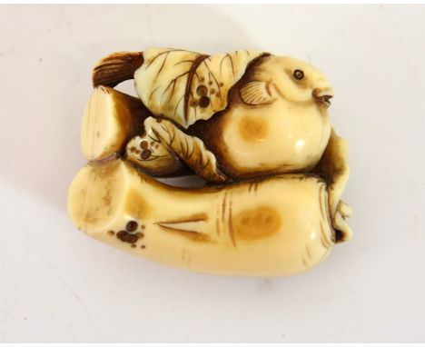 λ A Japanese carved ivory netsuke, Meiji, modelled as root vegetables with fish, 4cm long