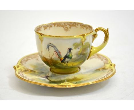 A Hadleys Worcester cabinet cup and saucer, lobed and painted with a pheasant in open countryside, relief moulded and gilt fo