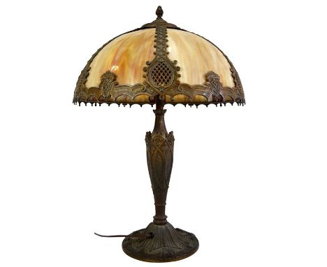 An American cast metal and slag glass table lamp, circa 1920, six panel marbled opaque brown panels within relief moulded dom